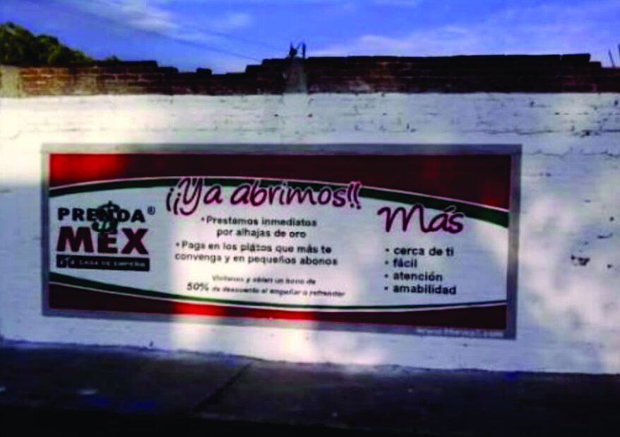 Barda con el anuncio de apertura de Prenda Mex casa de empeño